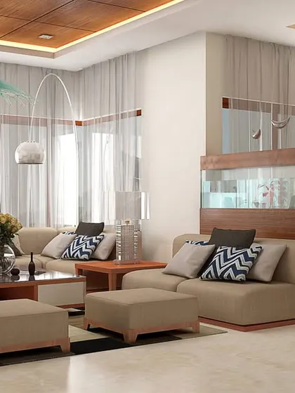 A bright and airy living room with a neutral color scheme. The large sectional sofa and ottomans provide flexible seating, while a custom partition with a built-in bookshelf cleverly divides the space.