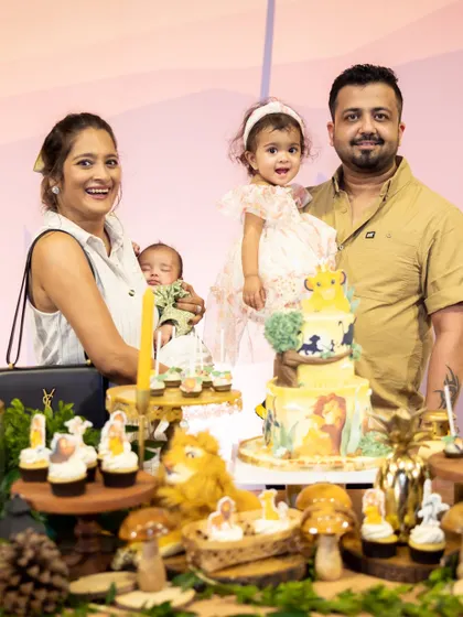 A heartwarming photo of the birthday girl's family at the Lion King dessert table, celebrating her second birthday with love and joy.