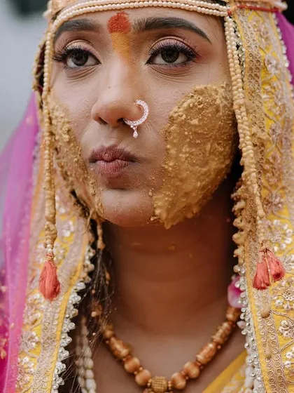 A candid close-up from a Marathi wedding's Haldi ceremony. Even covered in turmeric, the bride's personality and the ritual's significance are clear.