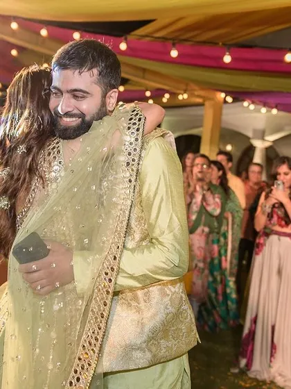 A warm hug on the dance floor, surrounded by friends and family.