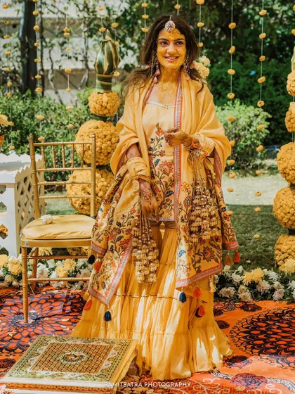 A full-length portrait of the bride in her beautiful floral Haldi outfit, complete with traditional Kaleerey.