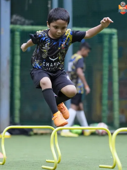 Leaping over hurdles, a young player works on his agility and coordination. These foundational exercises are crucial for developing athletic ability and preventing injuries.