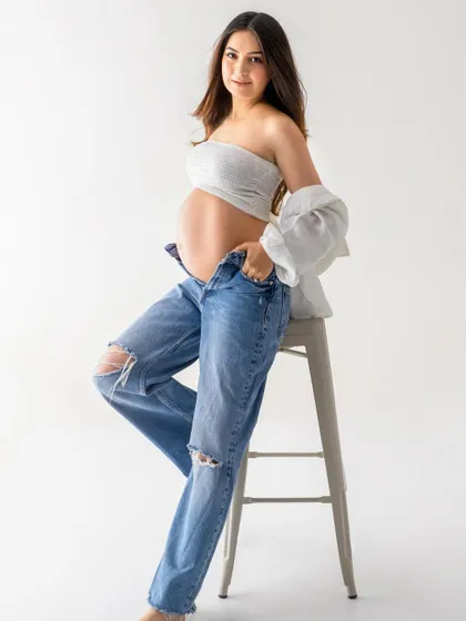 A confident solo portrait that's both casual and glamorous. This shows how a simple outfit can be styled to create a stunning and modern maternity photo.