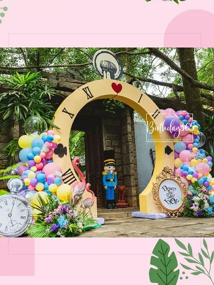 The grand entrance to our Alice in Wonderland party, featuring a giant clock archway, character cutouts, and colorful balloon garlands.