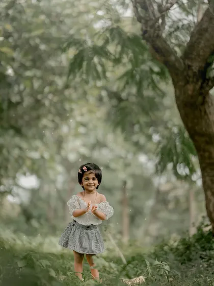 Clapping her hands with glee, this little one is having a wonderful time during her outdoor photoshoot.