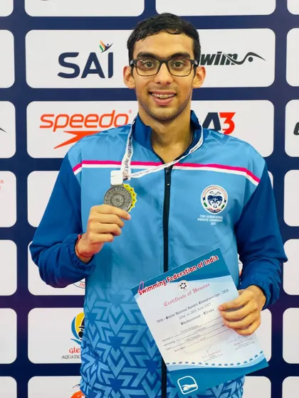 Our swimmers often share the podium, a testament to our competitive internal training environment. Here, Shoan Ganguly holds his bronze medal for the Men's 200m Freestyle, standing alongside his victorious teammate.