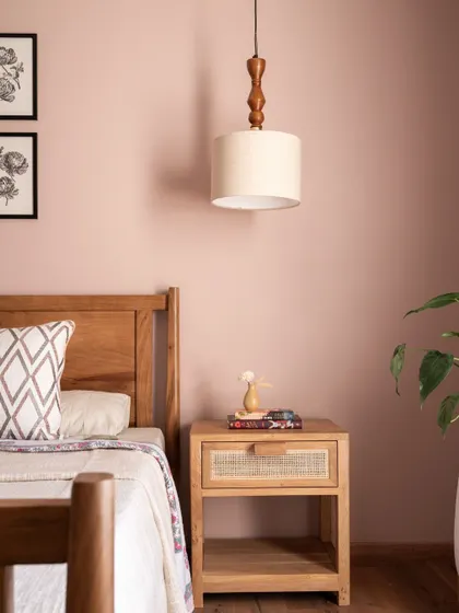 A detail of the parents' bedroom, showing the simple wood and cane nightstand and a classic pendant light. We love the simplicity of this space and how it still feels so put together.