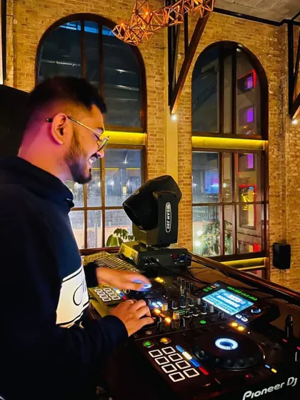 A candid shot of me enjoying the moment while mixing at a beautiful venue with large arched windows. Good music, good friends, and good vibes are what it's all about.
