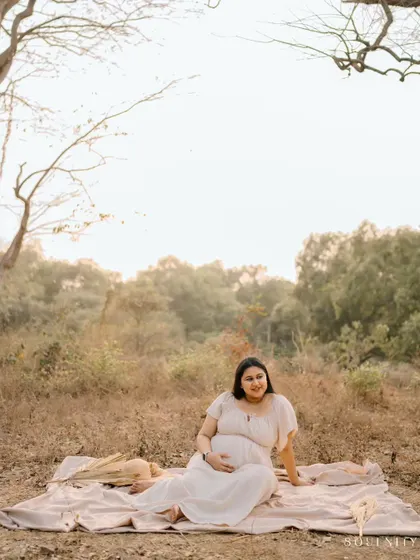Surrounded by the quiet beauty of nature, this mama-to-be takes a moment to connect with the little life she is nurturing.