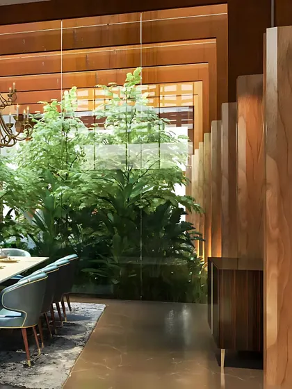 A dining area separated by elegant wooden fins, with a lush indoor garden visible through a glass wall, perfectly illustrating our biophilic design approach.