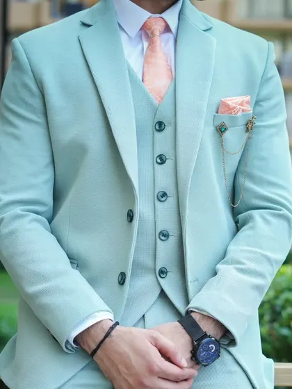 A detailed shot of the mint green suit, focusing on the fabric and the fit of the waistcoat.