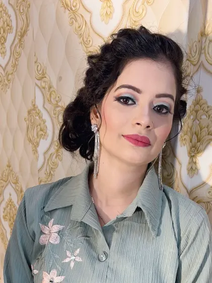 A fresh and modern party look. The makeup features a light blue-green eyeshadow and a soft pink lip, paired with a simple hairstyle.