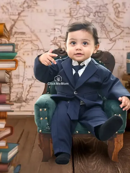 This little boss is ready to take on the world. The classic suit and stack of books create a powerful and adorable portrait.