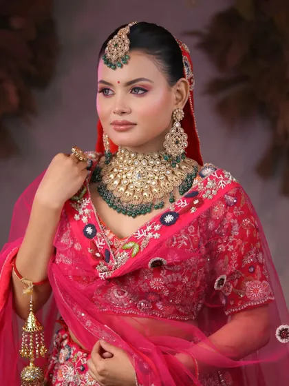 A side profile showcasing the complete bridal ensemble, from the elegant bun and maang tikka to the flawless makeup.