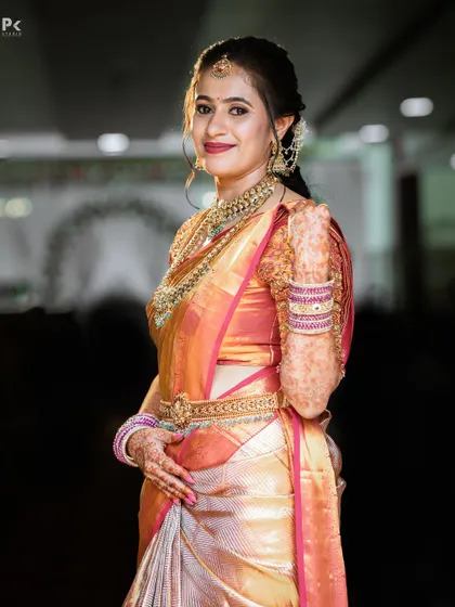 A side profile of the bride, highlighting the flawless makeup and the way it complements her intricate jewellery and the shimmer of her silk saree.