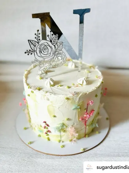 A floral monogram topper in silver mirror acrylic looks stunning on this pastel cake. The engraved floral details add a delicate touch to the bold initial.