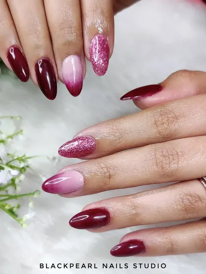 A stunning set of wine-colored nails with an ombré effect and a touch of glitter. The deep wine fades into a softer shade, creating a dramatic and elegant look perfect for any season.
