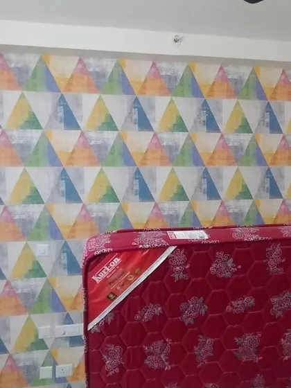 A bedroom wall with a colorful geometric triangle pattern.