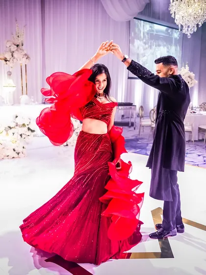 From the wedding ceremony to the reception, your style should tell a continuous story. For Munpreet and Manish's reception in Australia, we went for a classic red and black theme. She is a vision in a dramatic Gaurav Gupta ruffled gown, ready to dance the night away.