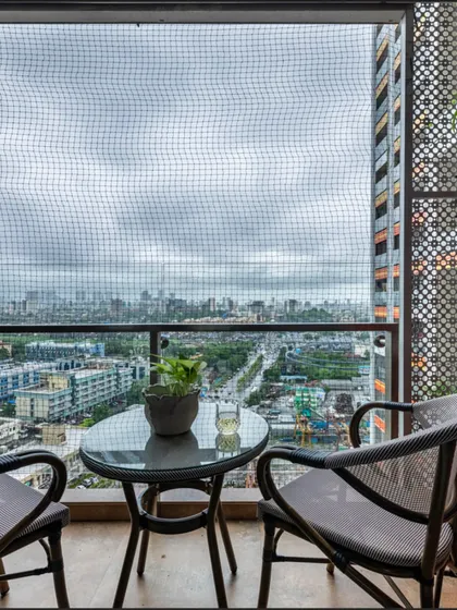This balcony seating area in The Filigree House offers a quiet escape with a view of the city. The simple yet chic outdoor furniture creates an inviting spot to unwind and enjoy a moment of peace above the bustling streets.