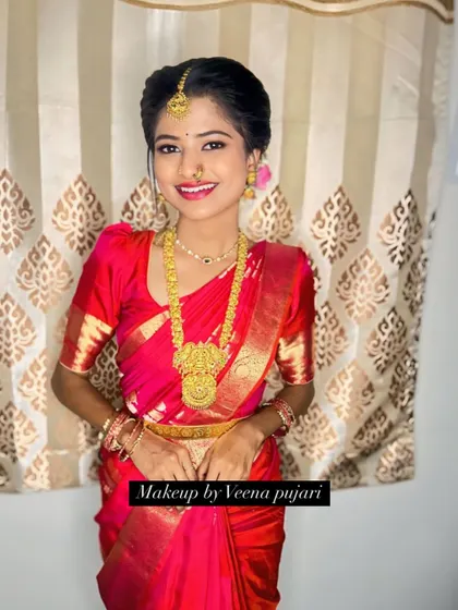 This bride's smile is the best accessory. Her makeup is kept classic and clean to let her natural beauty and the vibrant red of her saree stand out.