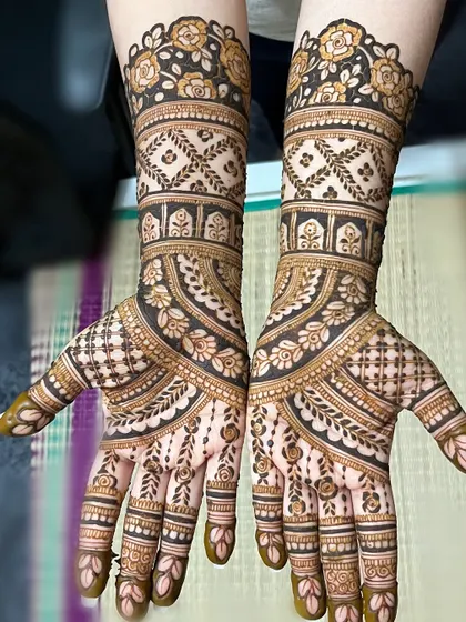 A beautiful example of a floral-themed bridal mehndi. The design features rose motifs at the top, with flowing patterns of leaves and vines that create a sense of harmony and grace.