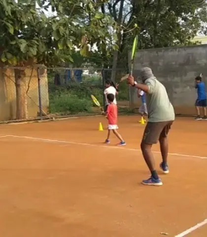 I demonstrate the correct ready position and volley technique to a group of young players. Group sessions ensure students learn from both instruction and observation.