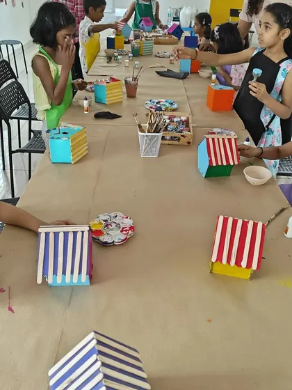 A long table of young artists building and painting their birdhouses. It's a fantastic group activity for a birthday.