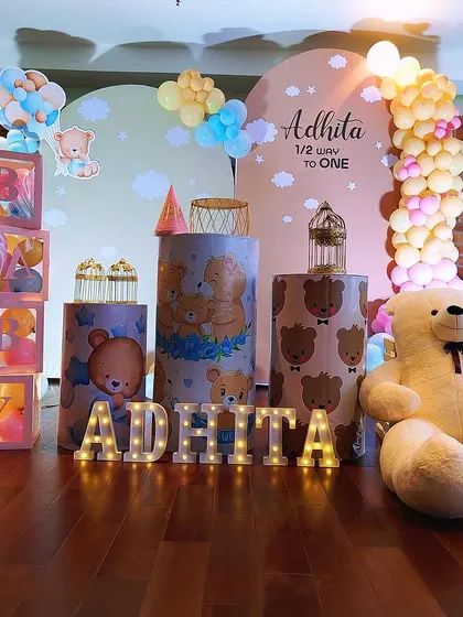 This half-birthday celebration features a sweet teddy bear theme. The decor includes themed pedestals, large teddy bears, and "BABY" blocks filled with pink balloons.
