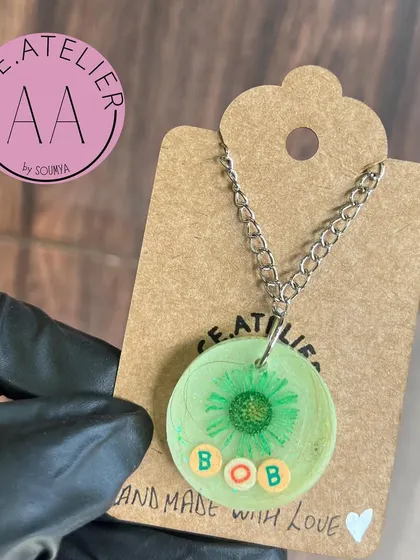 A simple and sweet memorial pendant for a pet named Bob. His hair is preserved in a light green resin circle, a small and personal way to keep his memory alive.