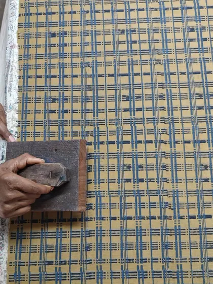 Here, we are printing on corduroy fabric using a natural resin discharge technique. It's always a joy for our artisans to experiment with different materials and see how our traditional methods adapt to new textures.
