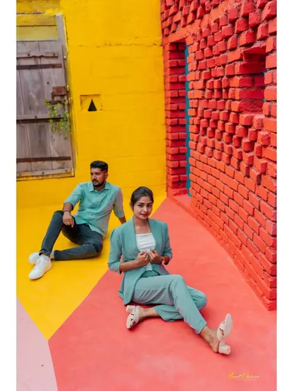 A stylish portrait of a couple posing in a colorful, geometric setting. Their modern outfits and confident poses make for a very chic photo.