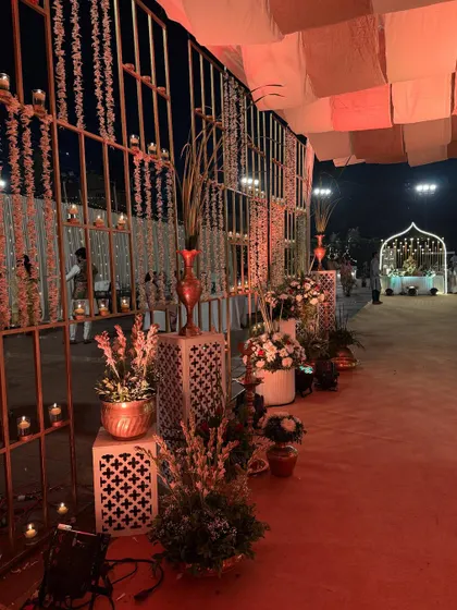 Another view of the warm, candle-lit entrance aisle. The combination of rustic textures, soft lighting, and fresh flowers is perfect for creating a welcoming and down-to-earth yet elegant vibe.