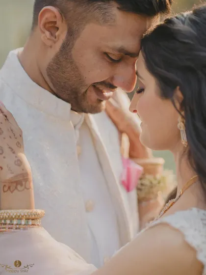 A soft and romantic close-up of a couple on their engagement day. The focus on their gentle expressions and the bride's henna-adorned hand tells a story of love and tradition.