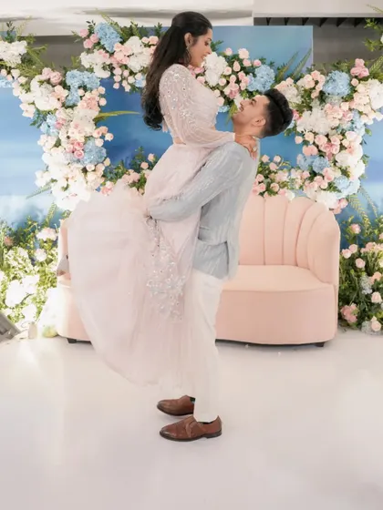 Yash and Sakshi share a dance at their engagement party. The backdrop of blue and pink florals against a sky-blue wall created a dreamy, pastel-perfect setting.