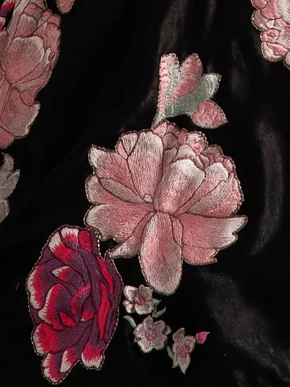 A close-up of luxurious black velvet adorned with intricate floral embroidery. Each garment I create is a masterpiece, embodying the essence of pure elegance.