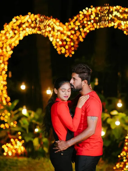 A tender and romantic embrace in front of the glowing heart prop.