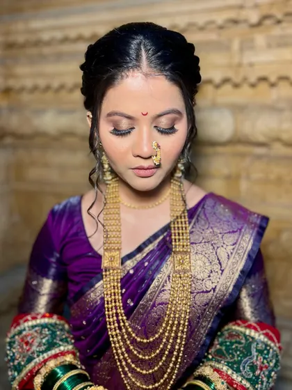 The eye makeup for this Maharashtrian bridal look was kept soft and shimmery, with tones that perfectly matched her purple and red saree for a harmonious finish.