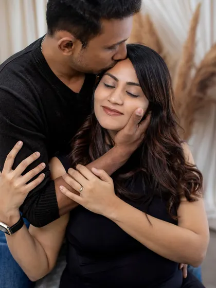 A sweet forehead kiss, a simple gesture that speaks volumes about the love and affection in the relationship.