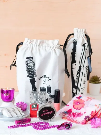 This "Gossip Girl" themed pouch is a fun gift for bridesmaids. It's filled with essentials like hair accessories, makeup, and a whistle, making it a perfect little survival kit for the wedding festivities.