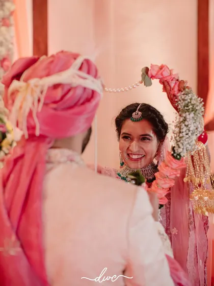 The bride's beautiful, happy expression as she looks at her groom during the Jaimala ceremony, a perfect candid moment.