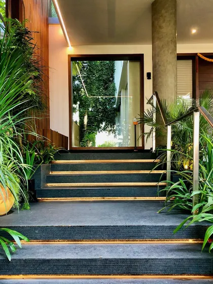 The main entry steps of Kanasu, surrounded by plants and lit from below, creating a dramatic and welcoming approach to the home.