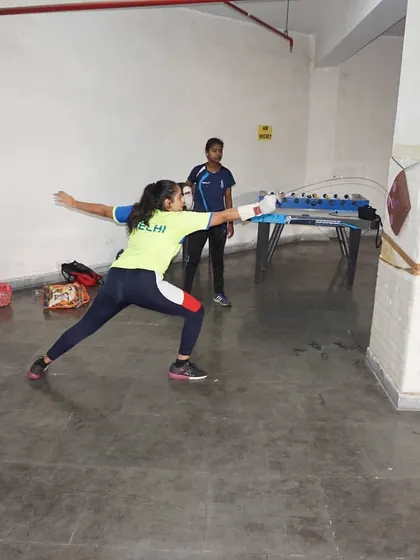 A student focuses intently on the target as she practices her lunge. Mental focus is just as important as physical skill in fencing.