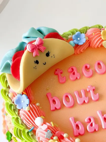A close-up of the adorable fondant taco and colorful piping on the baby shower cake.