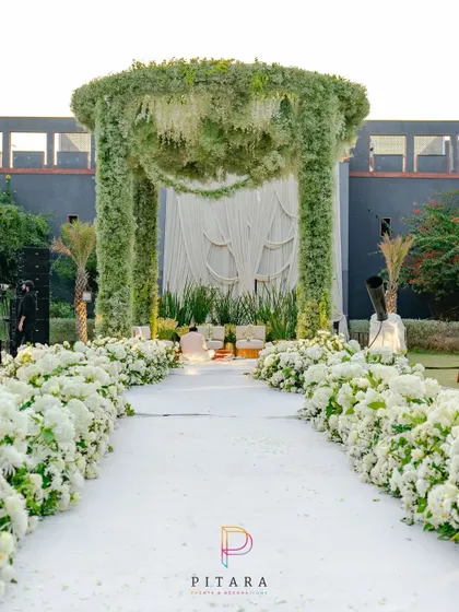 A walk to remember. This serene aisle, lined with a lush carpet of white hydrangeas and roses, leads to a mandap that feels like a piece of heaven on earth. It’s pure, timeless elegance.