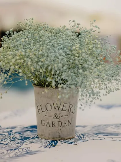 A delicate baby's breath arrangement in a rustic tin, part of a 'Carnival of Love' theme with a soft, aesthetic vibe.