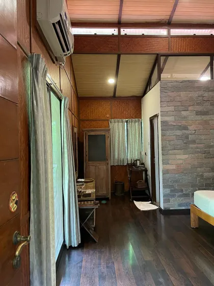 A glimpse into one of our rooms, showcasing the warm wooden interiors and a doorway leading to more beautiful views.