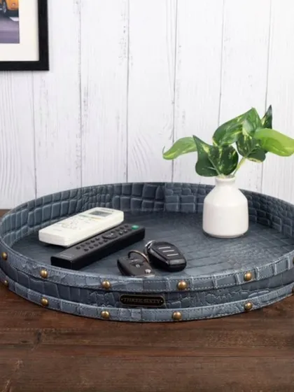 A lifestyle shot of a premium leather tray used as a catch-all for keys and remotes. This demonstrates the product's everyday utility and stylish presence in a home environment.