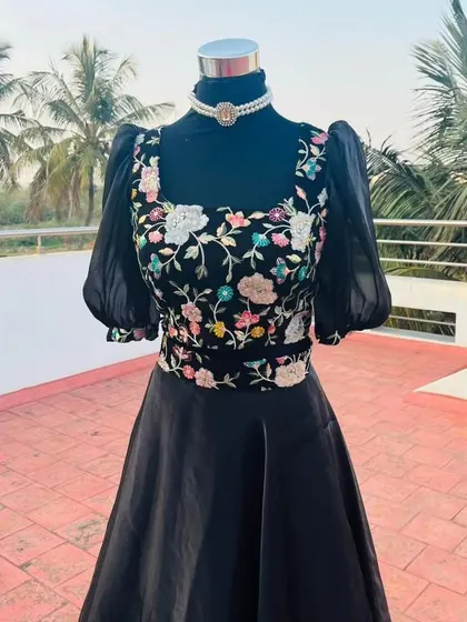 A close-up of the beautiful embroidery on the black crop top.