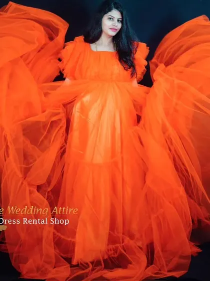 A dramatic studio shot with the orange ruffled gown, where the tulle is spread out to create a stunning butterfly effect. This shows the creative possibilities for your indoor maternity session.